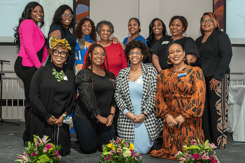 A group of people pose for a photo together at an event.