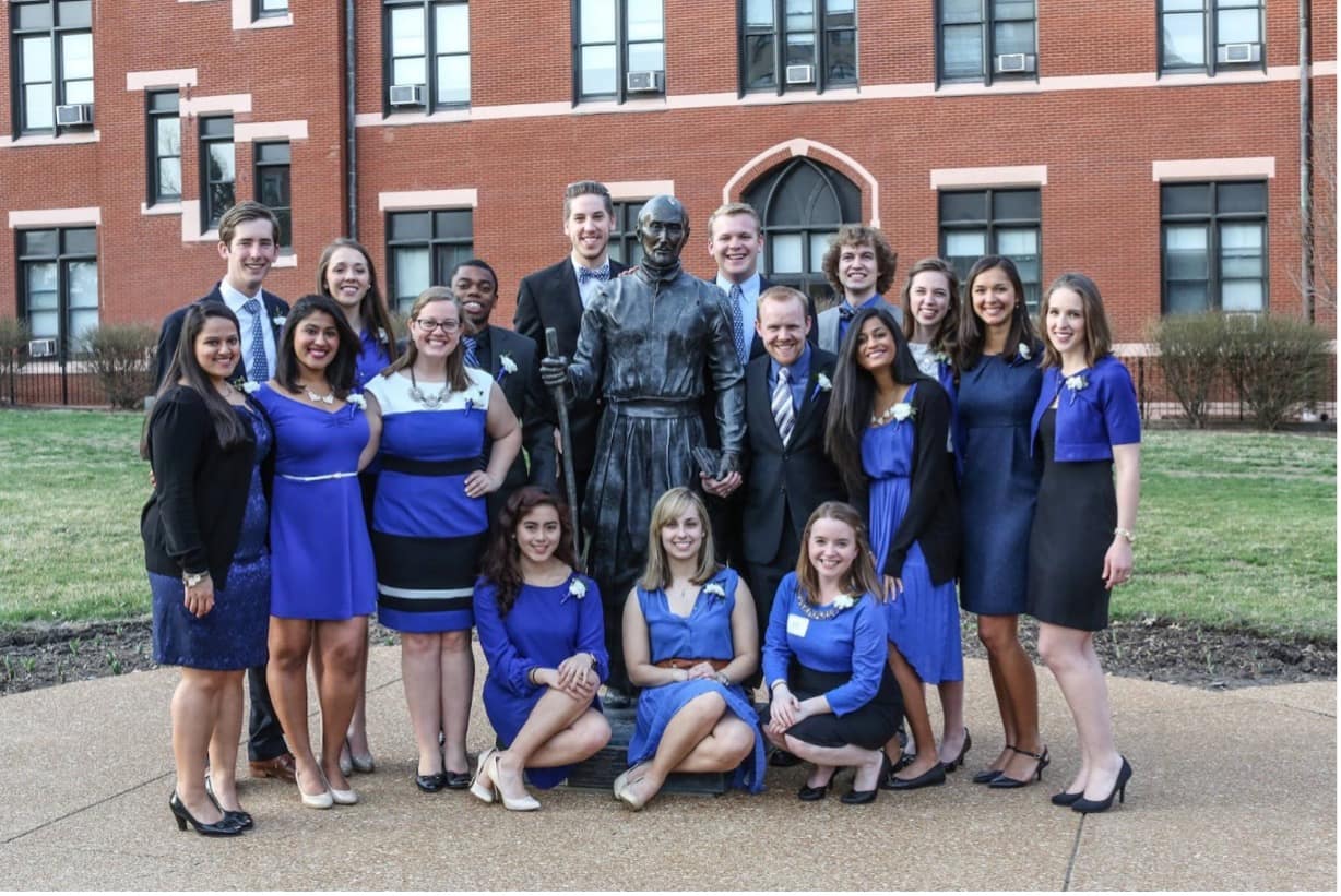 A group of students pose for a photo together outside on campus.