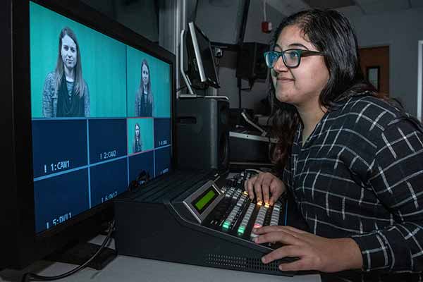 A female student edits video footage in SLU’s communication lab.