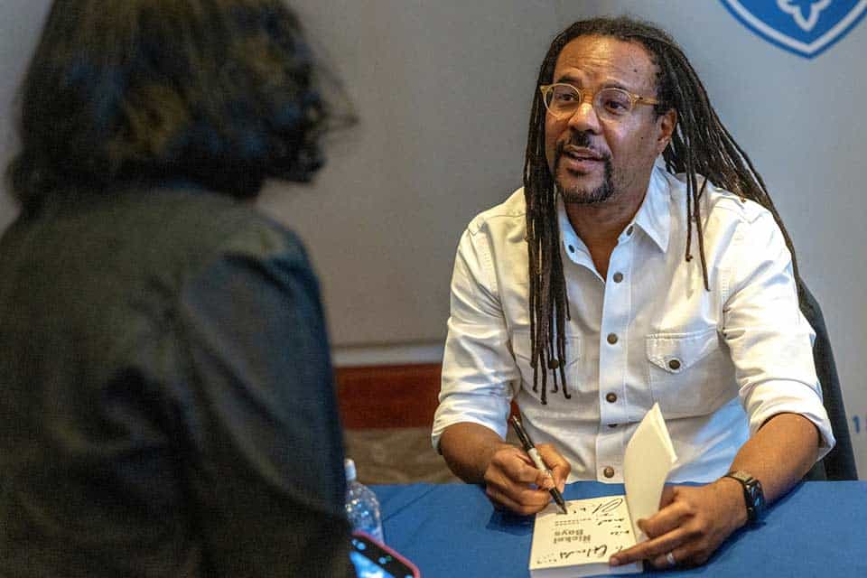 Colson Whitehead signs a copy of a book for a SLU student.