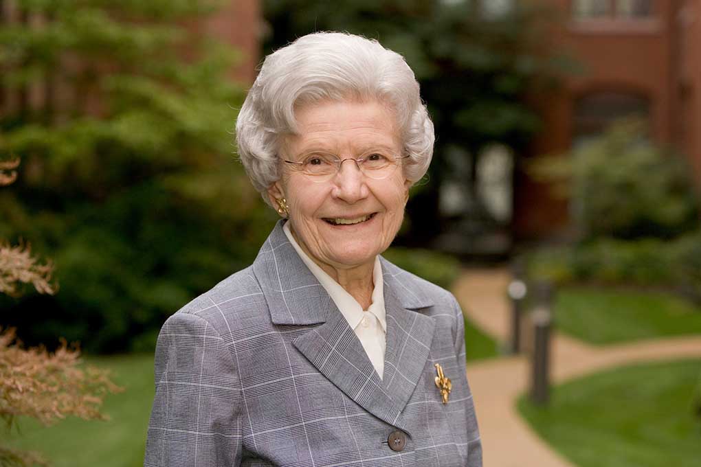 A portrait of Mary Bruemmer with SLU's campus in the background.