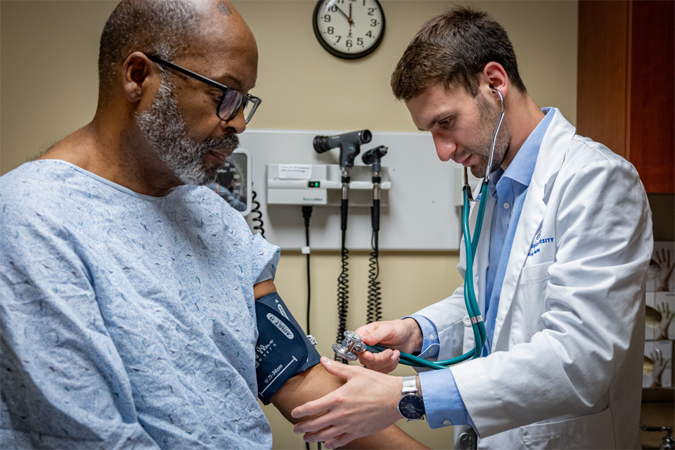 A student giving care in a simulated setting with a standardized patient