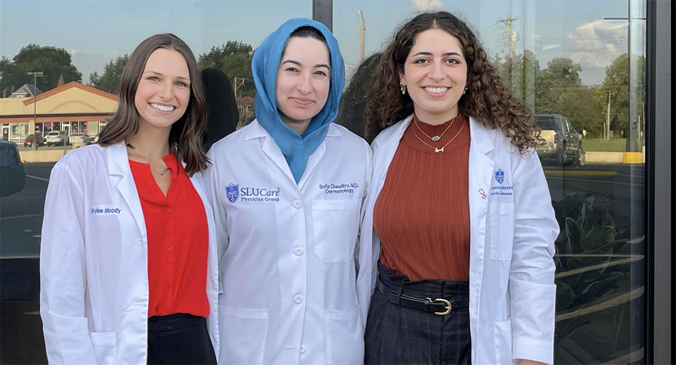 Faculty and students stand in front of the clinic window.