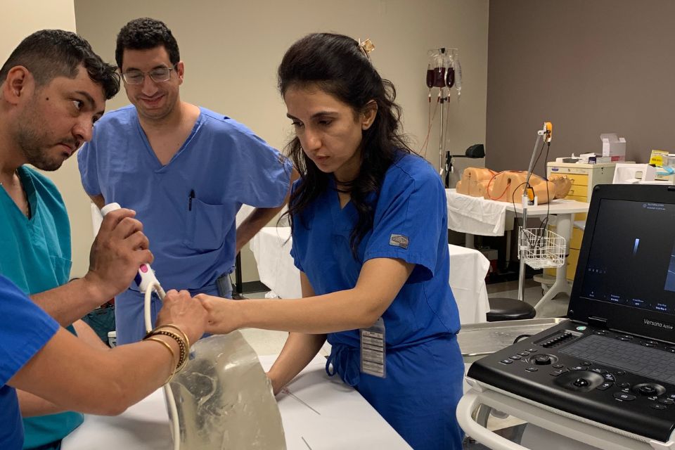 A group of nephrology fellows complete a kidney biopsy simulation training inside a hospital training room