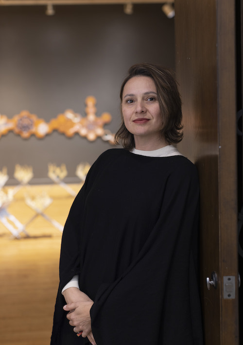 Beliz Iristay Beliz Iristay stands in the foreground while examples of her ceramic works are visible in the background
