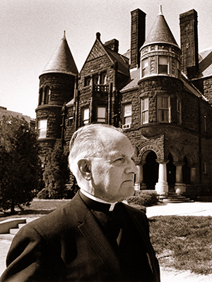 Maurice McNamee, S.J. standing in front of Samuel Cupples House