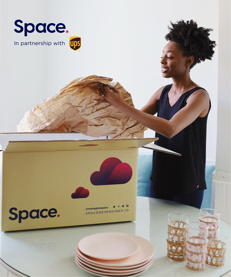 Young woman packing dishes into a storage box