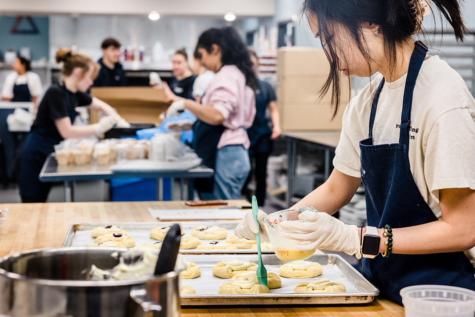 A student with Fresh Gatherings prepares a meal.