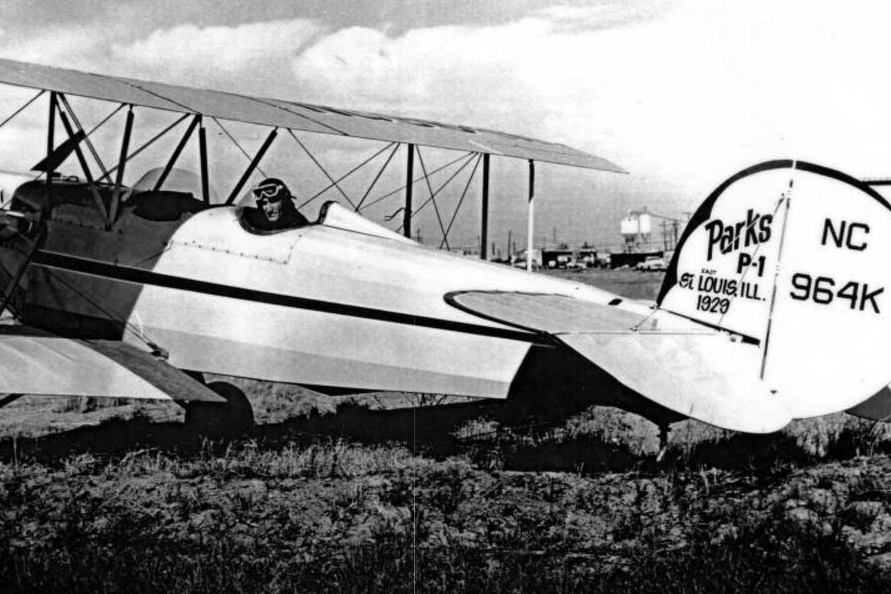 A pilot pictured in the cockpit of a historic plane with the rudder reading Parks P-1 St. Louis, Ill 2019