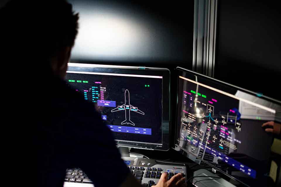 A student in profile looking at the screen of a flight simulator program